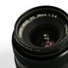 Detailed image of a Canon lens showcasing its aperture and reflections.