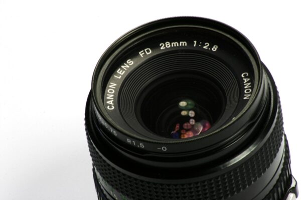 Detailed image of a Canon lens showcasing its aperture and reflections.